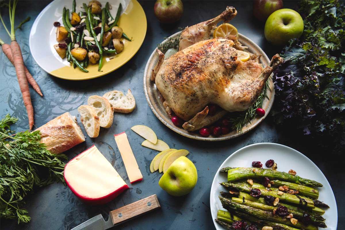 Shenandoah Valley Organic Farmer Focus chicken roasted whole on a table with sides | Food Related | San Antonio TX